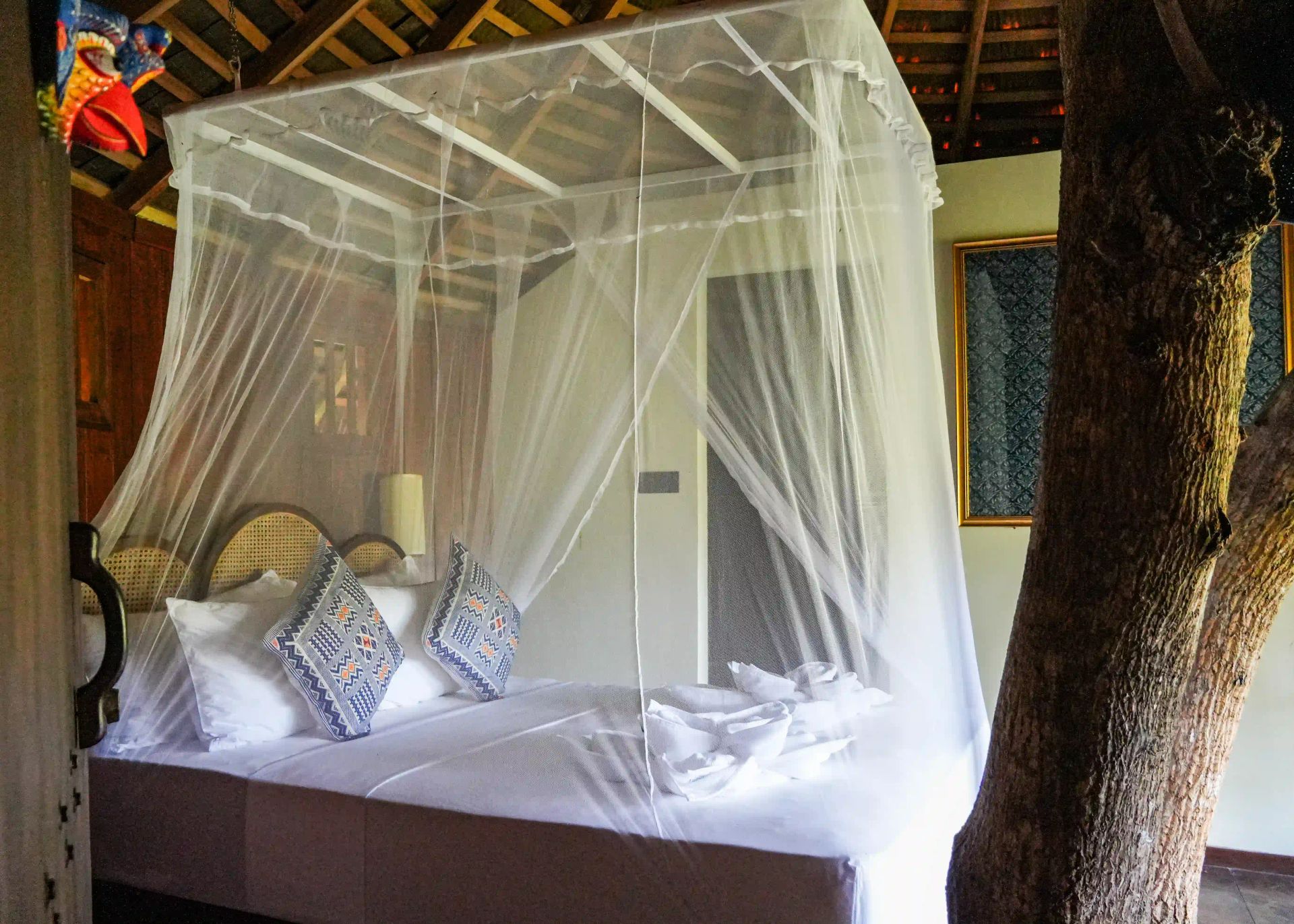 Interior of the lodge with a queen-size bed and mosquito net.